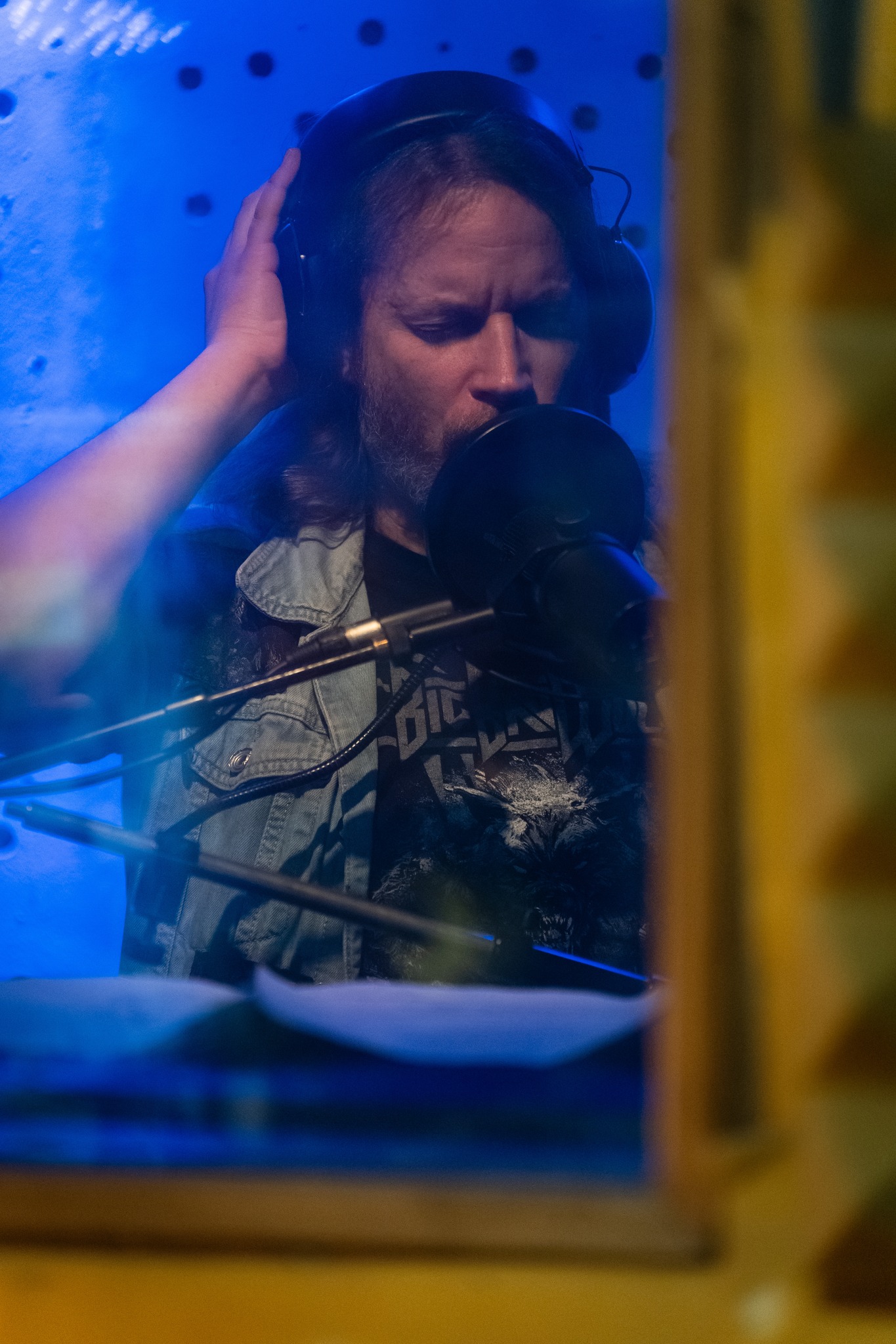 Vocalist recording with headphones in the studio